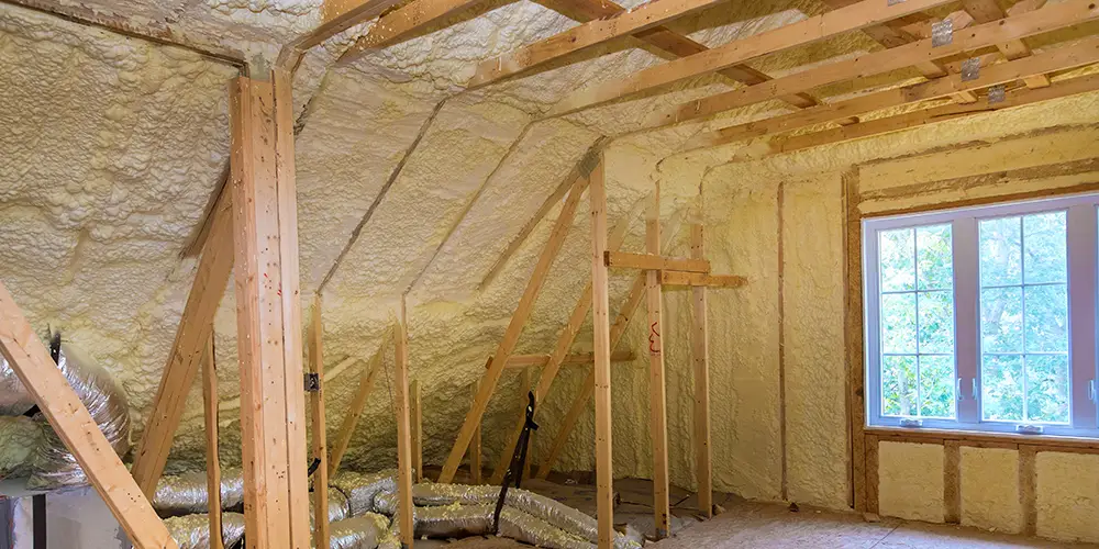 Spray foam insulation installed between attic rafters by JDH in Maryland