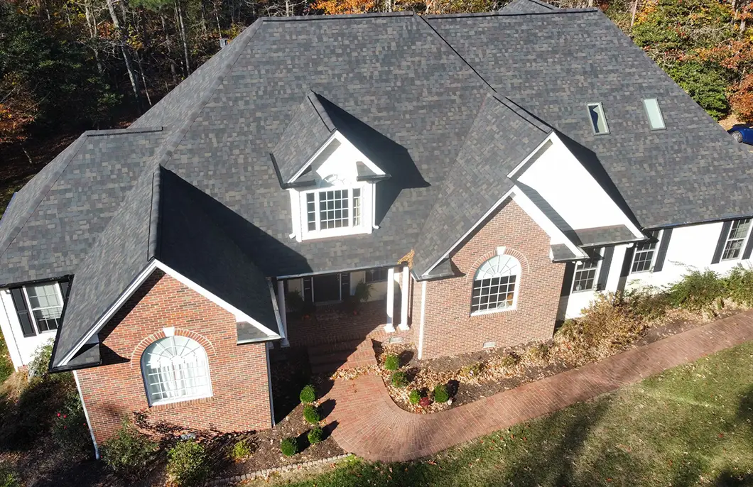 Aerial view of a completed Owens Corning Duration Black Sable Designer asphalt shingle roof installation on a Lexington Park Maryland brick home by JDH Remodeling