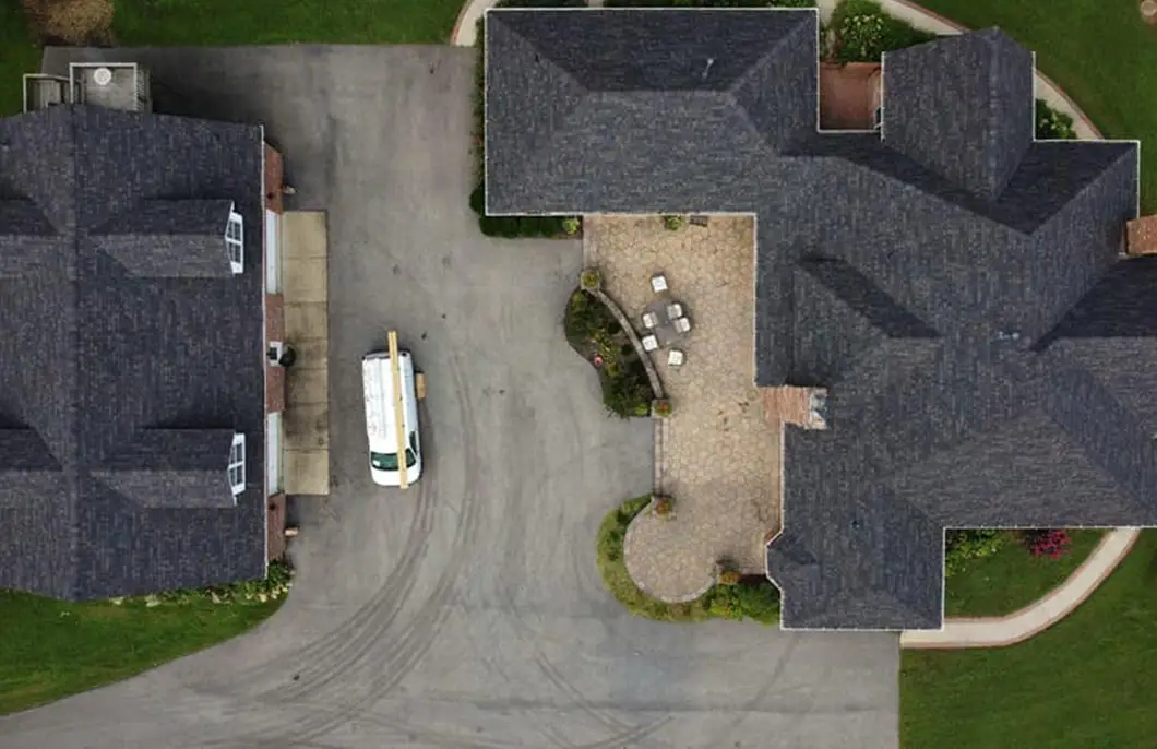 Aerial view of a Huntingtown Maryland residential neighborhood with multiple homes featuring dark Owens Corning Duration Black Sable roofing and manicured lawns documented by JDH Remodeling