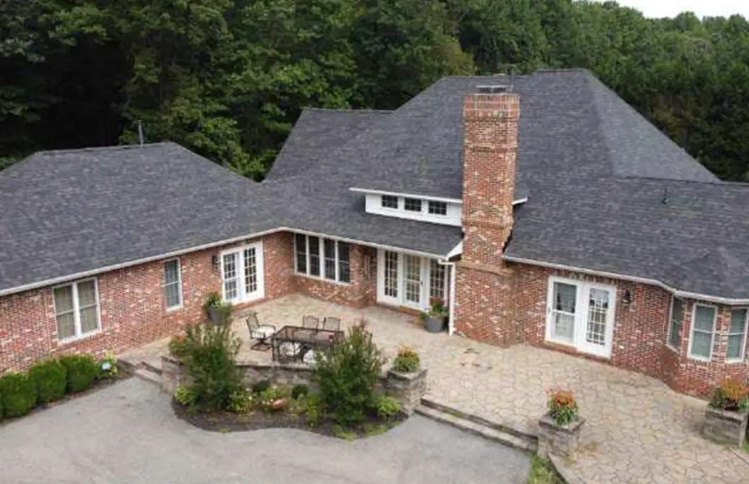 JDH Remodeling completed aerial view of an Owens Corning Duration Black Sable insurance-claim roof replacement on a Mechanicsville Maryland brick home with courtyard inside the 20659 footprint