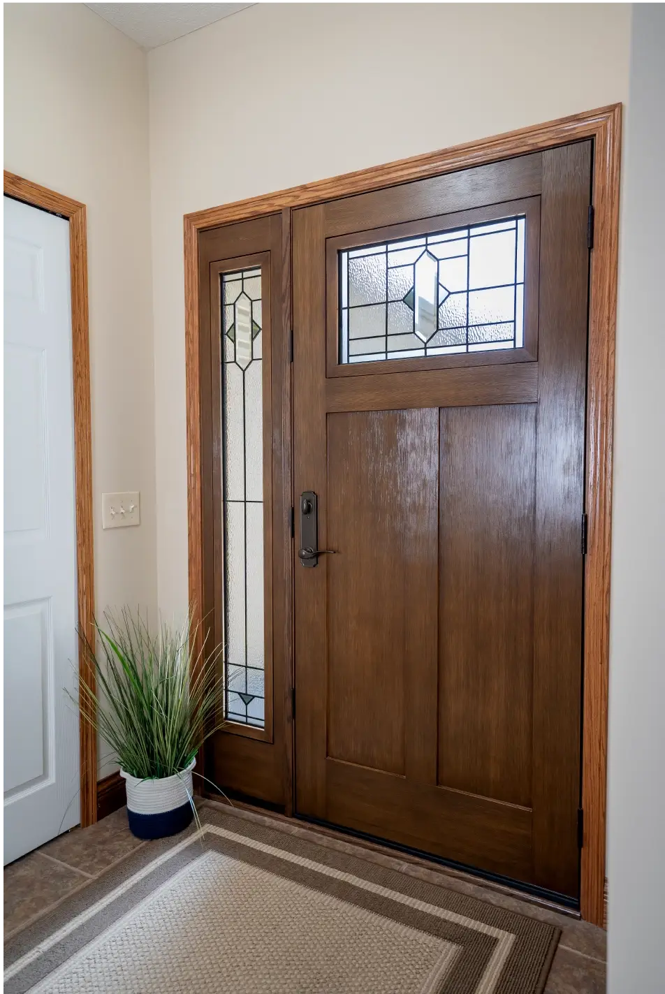 JDH Remodeling installation of a craftsman entry door with decorative glass panels, sidelights, and wood trim in a Maryland modern foyer, financed through JDH door financing