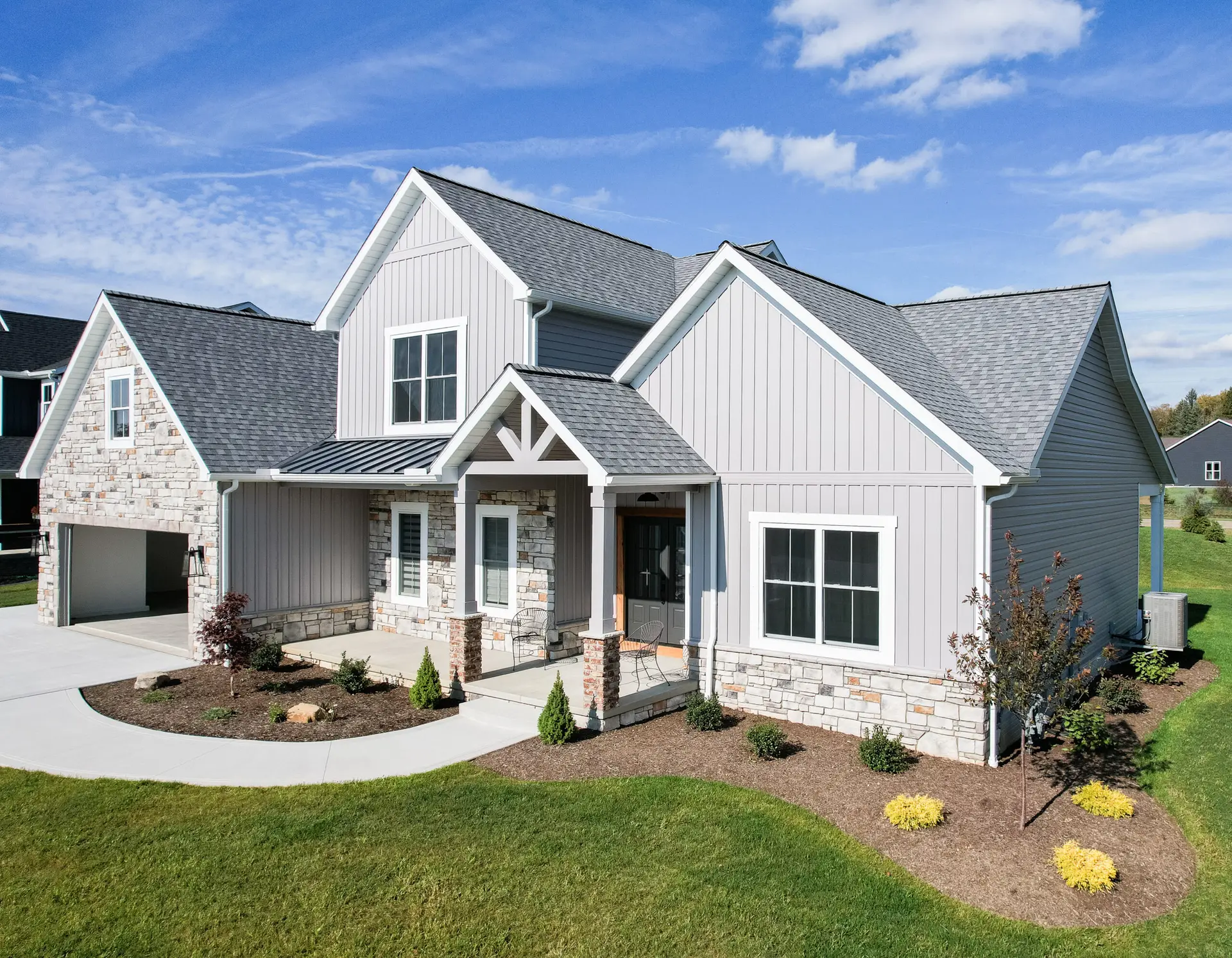 JDH Remodeling clean white board-and-batten siding with black-framed windows and wooden soffit overhang on a modern Dunkirk Maryland home