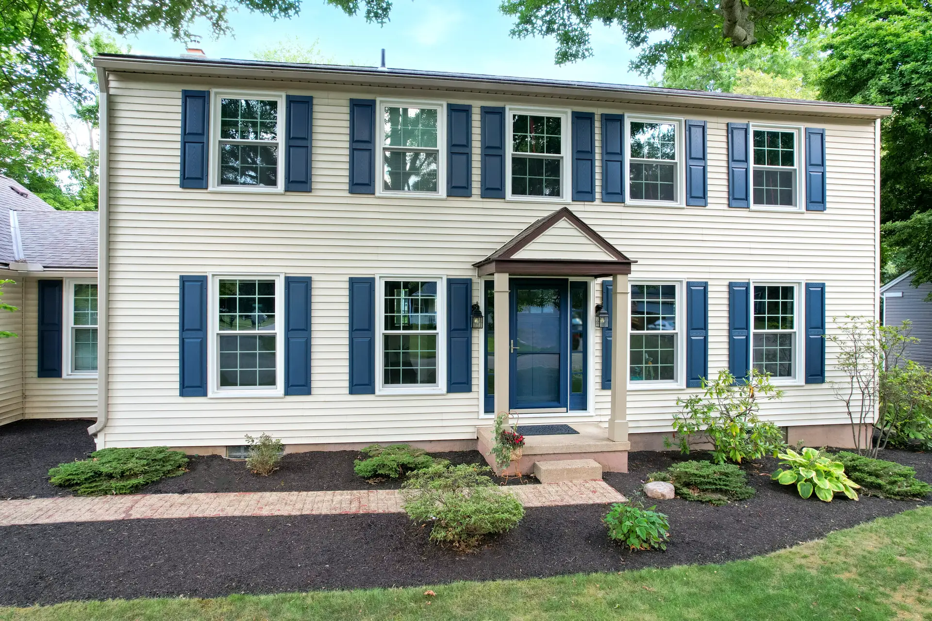 JDH Remodeling siding installation on a Lexington Park Maryland two-story colonial with white siding, blue shutters, and replacement windows