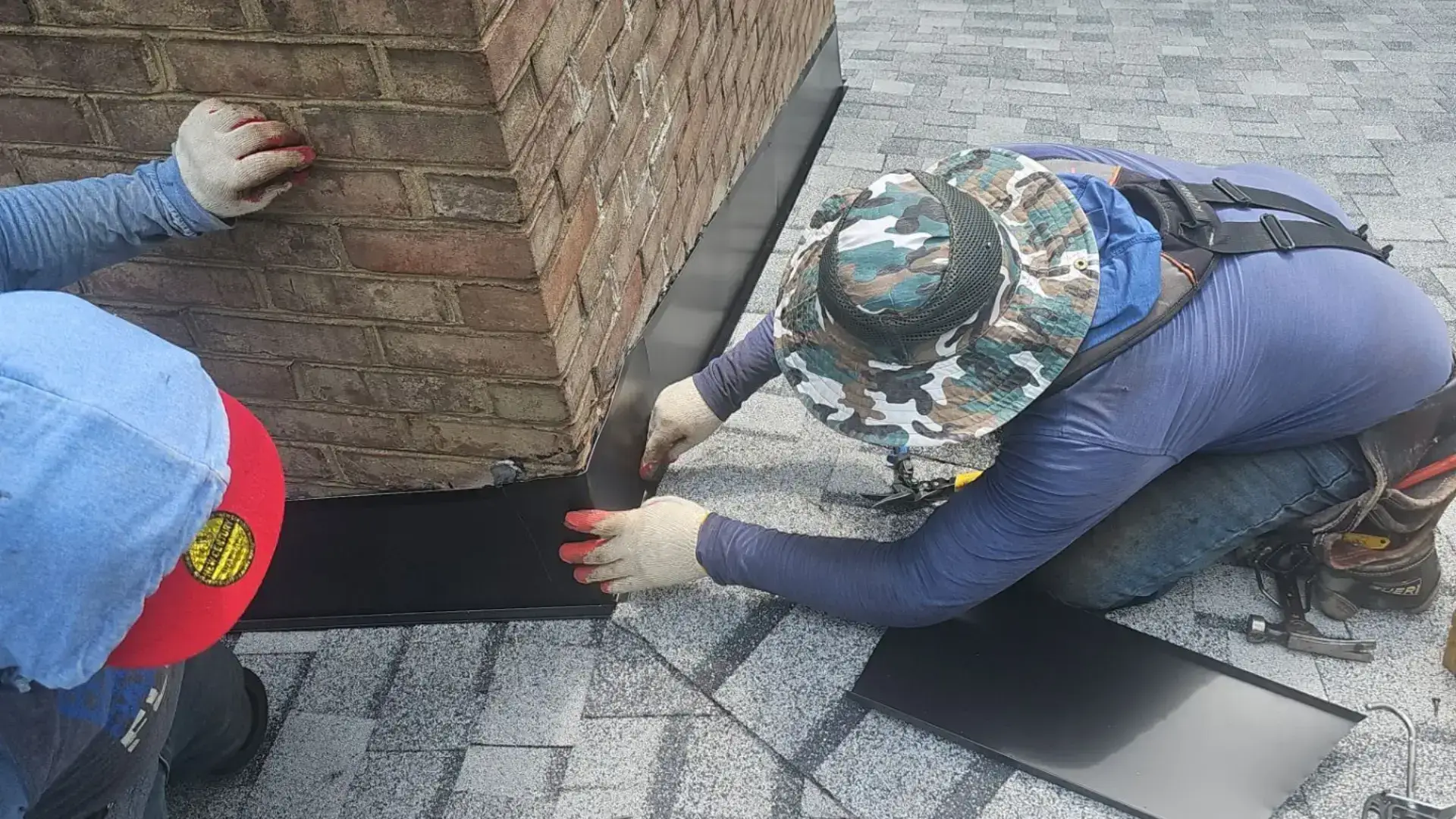 Professional roofing company loveville md installing new chimney flashing on a brick chimney. Ensuring a watertight seal for long-lasting roof protection.