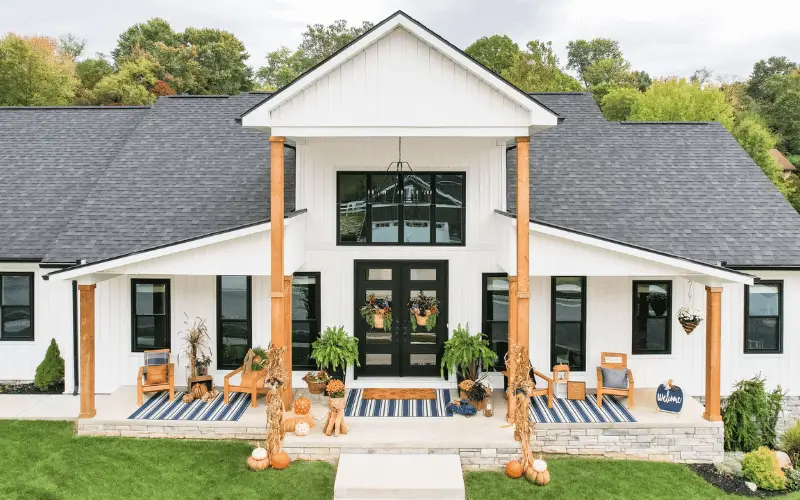 Maryland farmhouse exterior in spring with new siding showing seasonal maintenance touch points including gutters drainage and roof