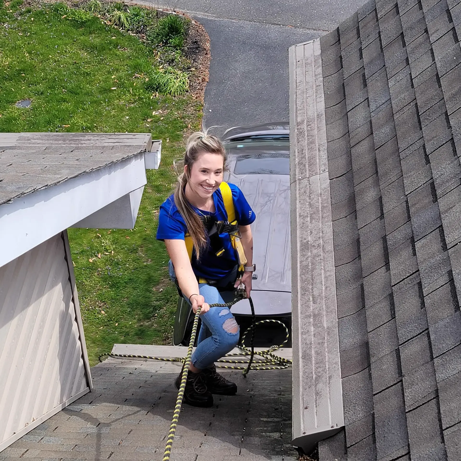 Sam Dodson, General Manager at JDH Remodeling, on a residential roof in a JDH-branded shirt and safety harness during a homeowner inspection in Southern Maryland