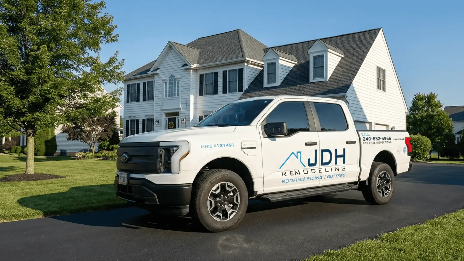 JDH Remodeling modern blue and black Port Republic Maryland home with new siding, replacement windows, stone accents, front porch and white columns