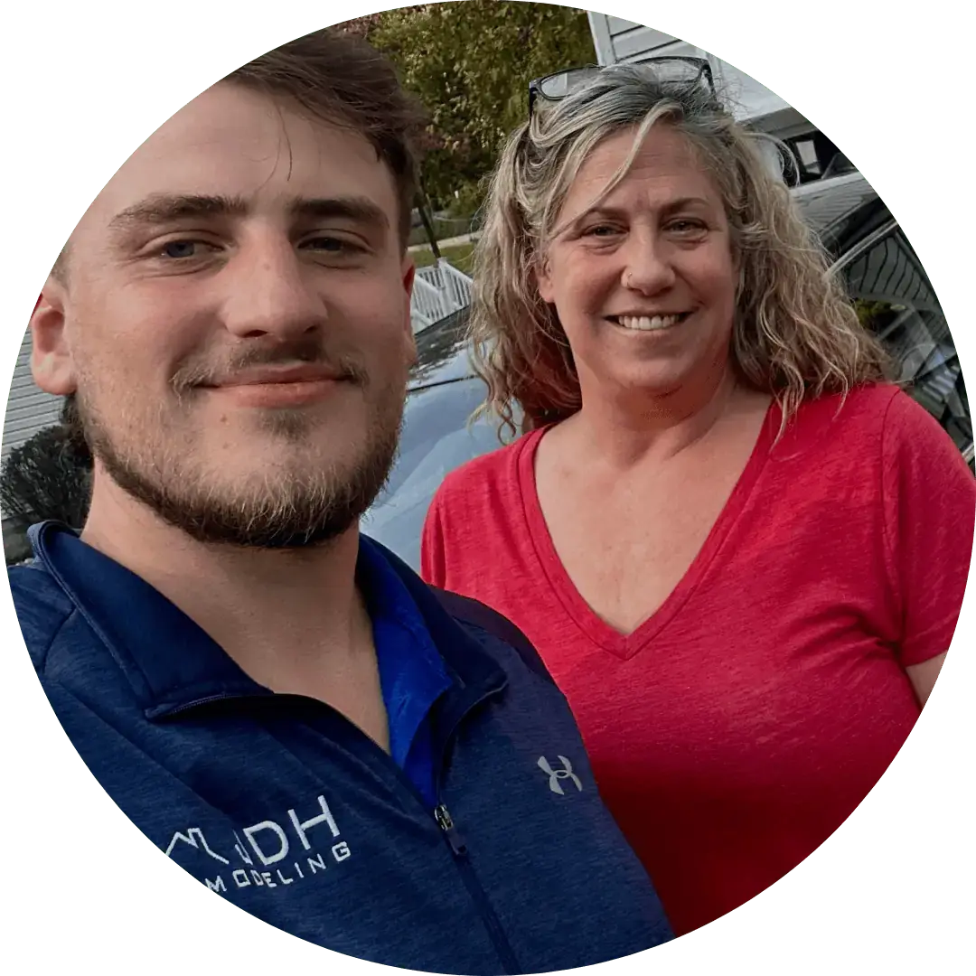 Two JDH Remodeling contractors posing together outdoors in Lusby Maryland branded apparel representing company team and professionalism