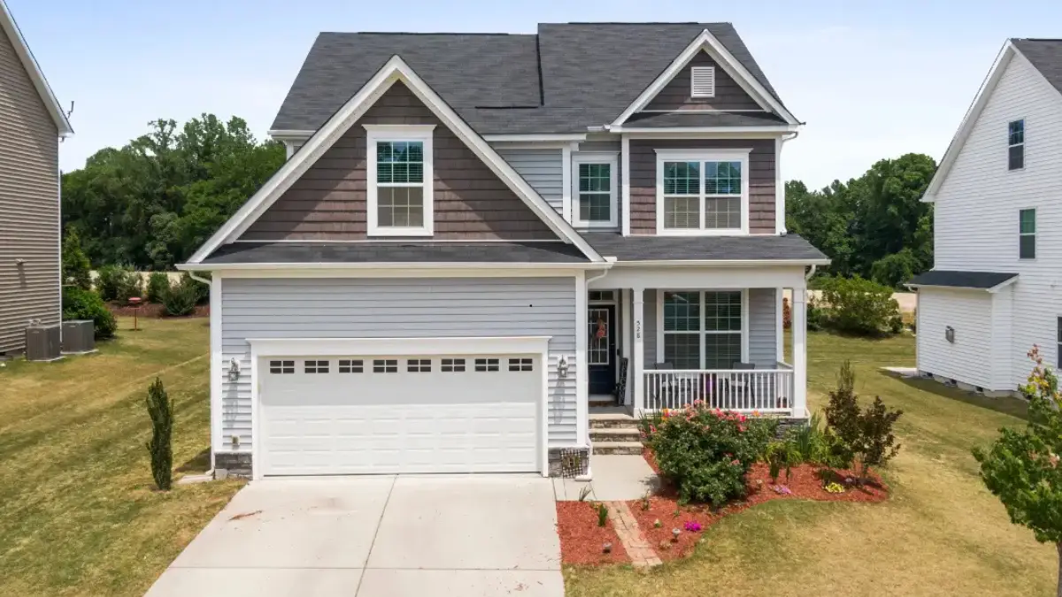 JDH Remodeling completed two-story Dale City Virginia home featuring new dark roofing, white siding, multiple windows, and professional landscaping in the Hylton-built single-family inventory
