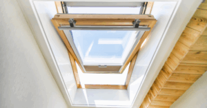 Venting skylight with wood trim partially open for fresh air circulation.