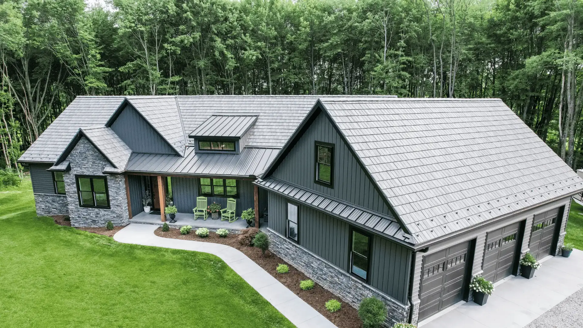 JDH Remodeling modern Hughesville Maryland farmhouse with standing-seam metal roof, dark siding, and stone accents representing the rural horse-country aesthetic