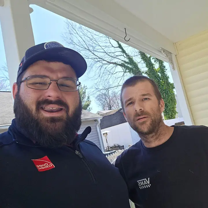 Satisfied Prince Frederick homeowner with JDH Remodeling crew after completing storm damage roof restoration
