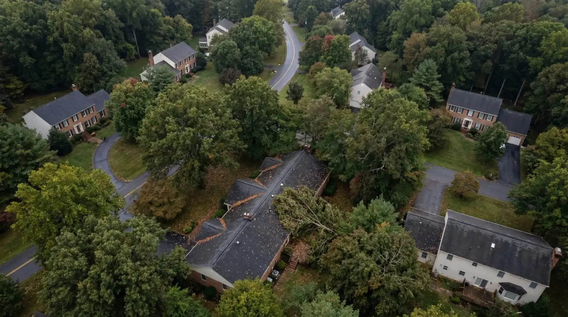 Aerial view of residential home with active roof replacement showing tear-off and new shingles installation in progress.