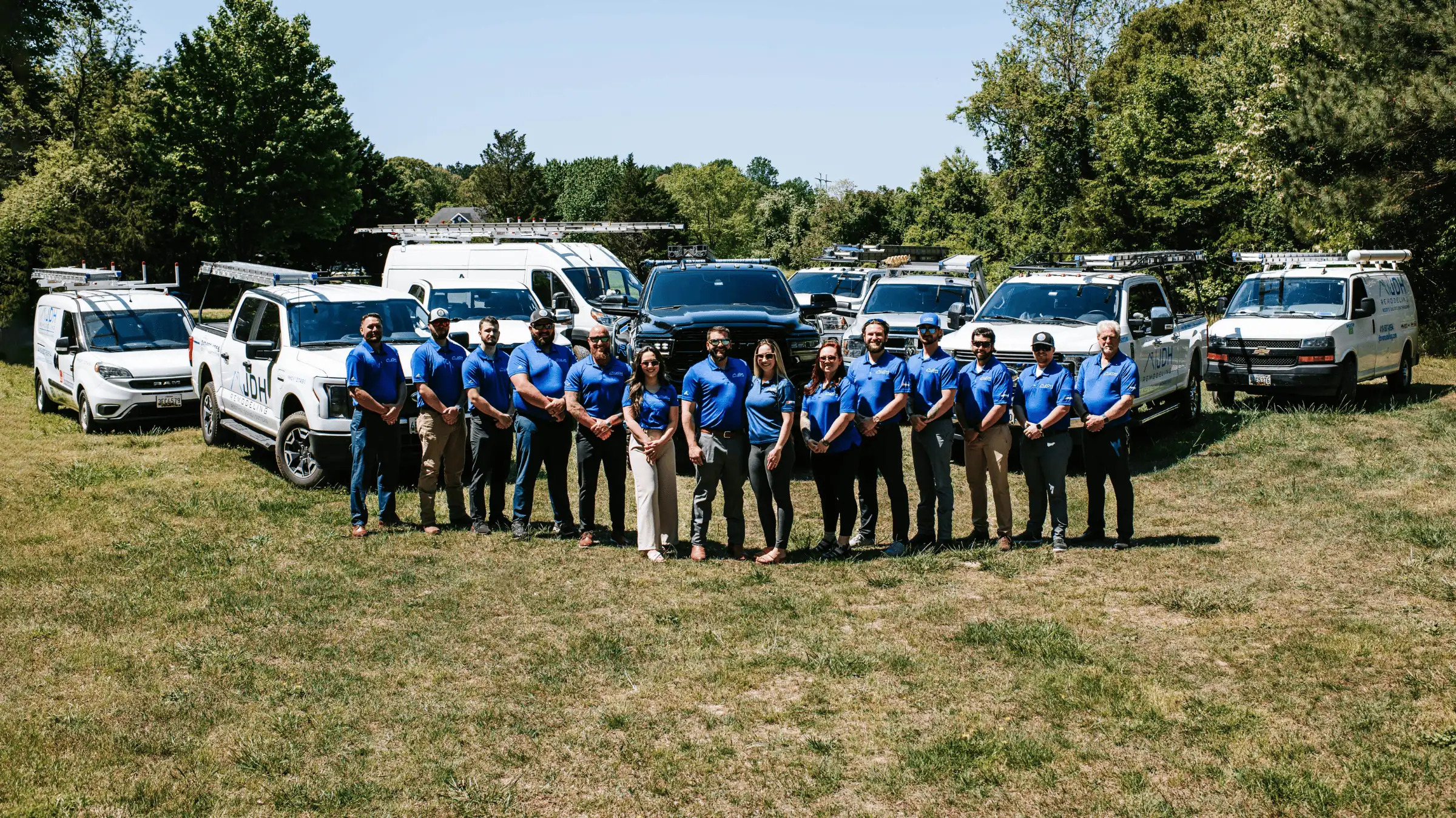 The JDH Remodeling team in front of company work trucks